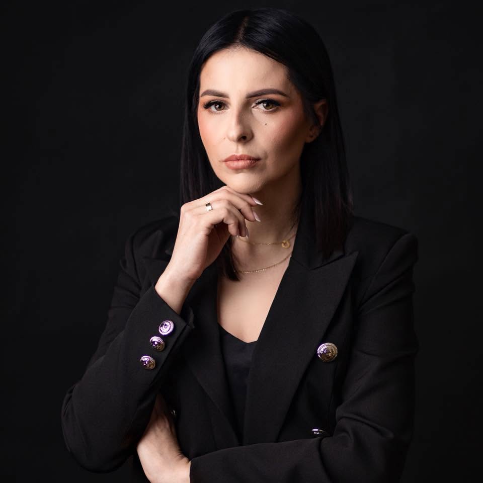 Magdalena Gudyka, linergistka z Limanowej, w czarnej marynarce na ciemnym tle